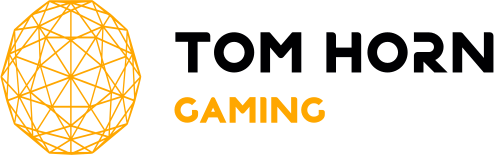 O desenho de uma esfera geométrica amarela está à esquerda, com o texto "TOM HORN" em preto e "GAMING" em amarelo à direita.